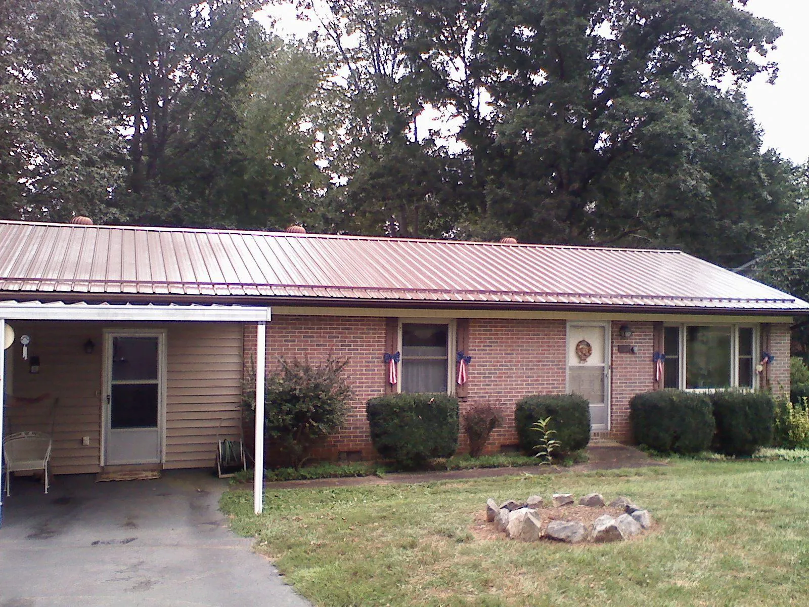Bronze metal roof and carport on a brick ranch home — Roof Repair work by our crew in Clarkdale